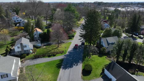 red car on street in american suburb neighborhood