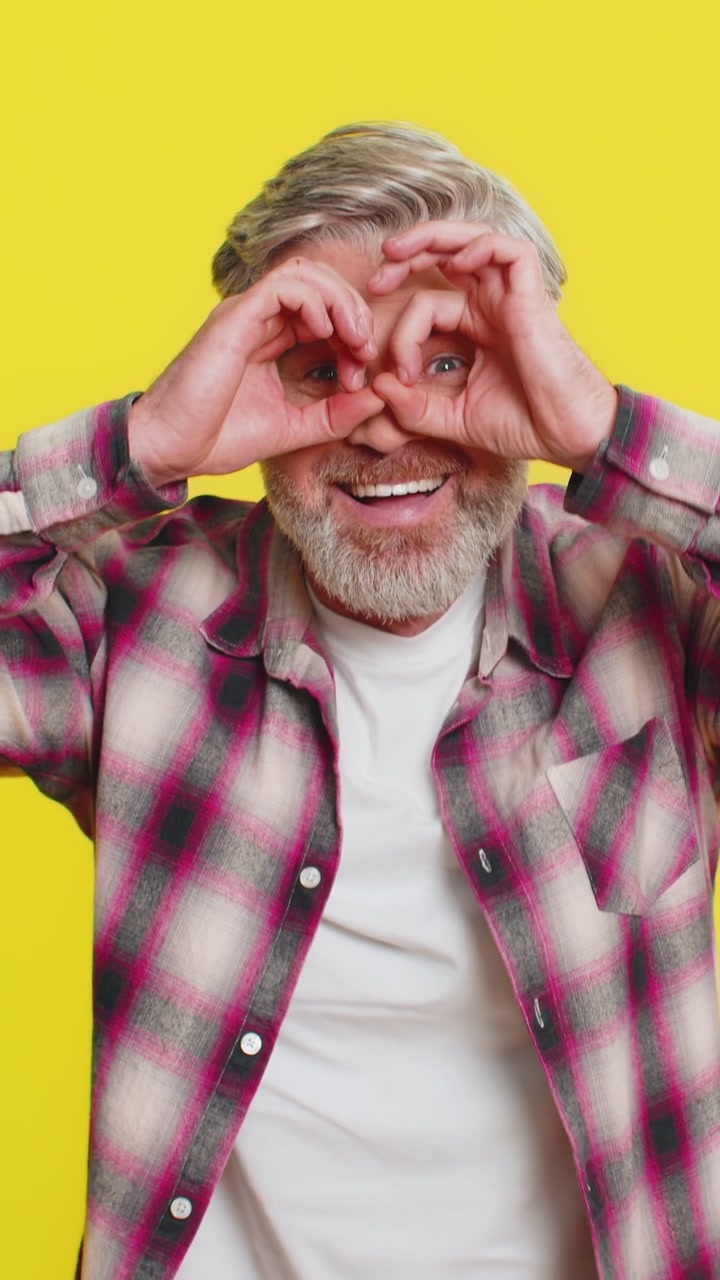 Mature man creating imaginary binoculars scanning horizon playful exploration friend search gesture