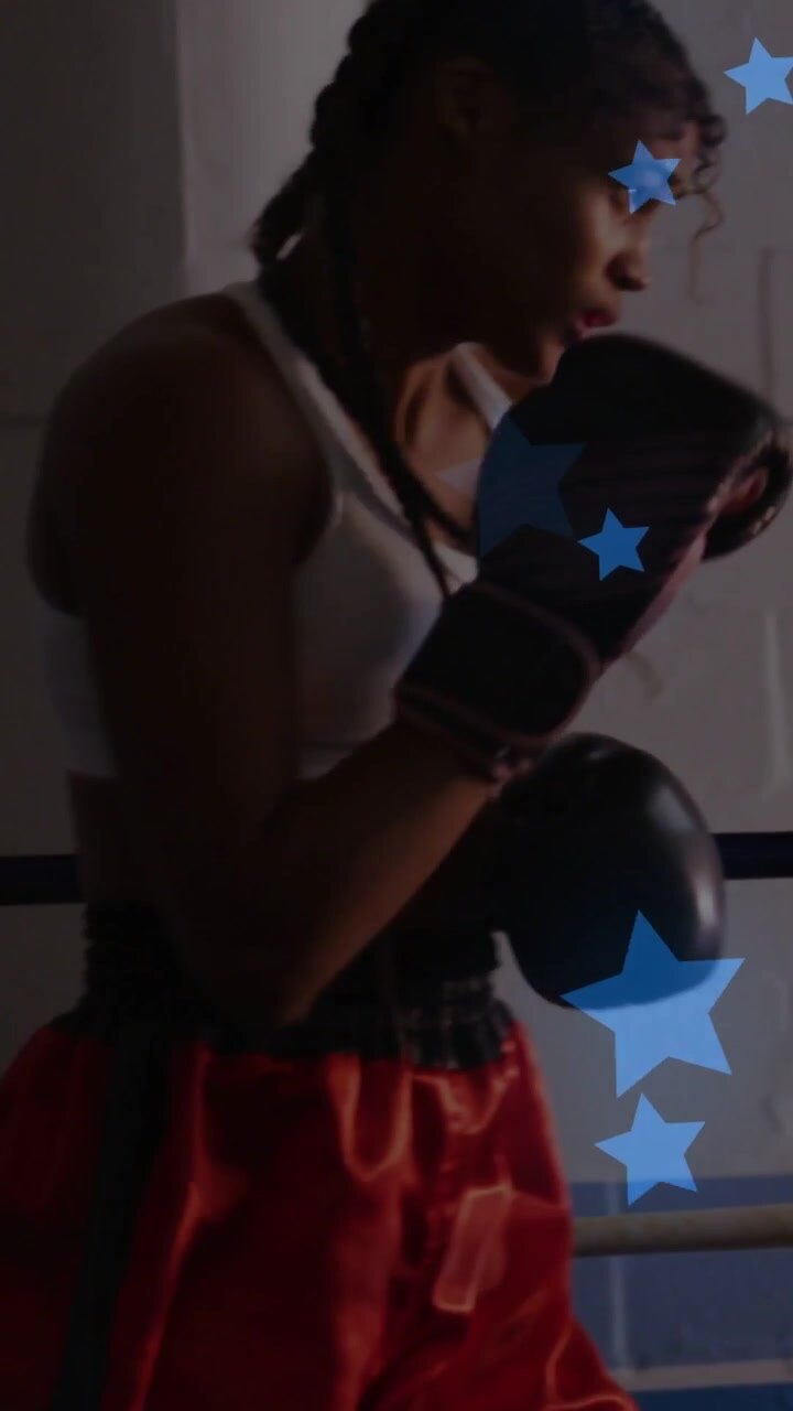 Pugile donna che cambia guardia e si muove a destra su indicazione dell'allenamento di boxe, con grafiche a stella blu che appaiono.