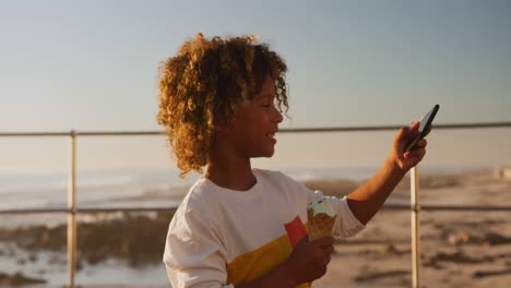 niño pequeño con un helado usando el teléfono