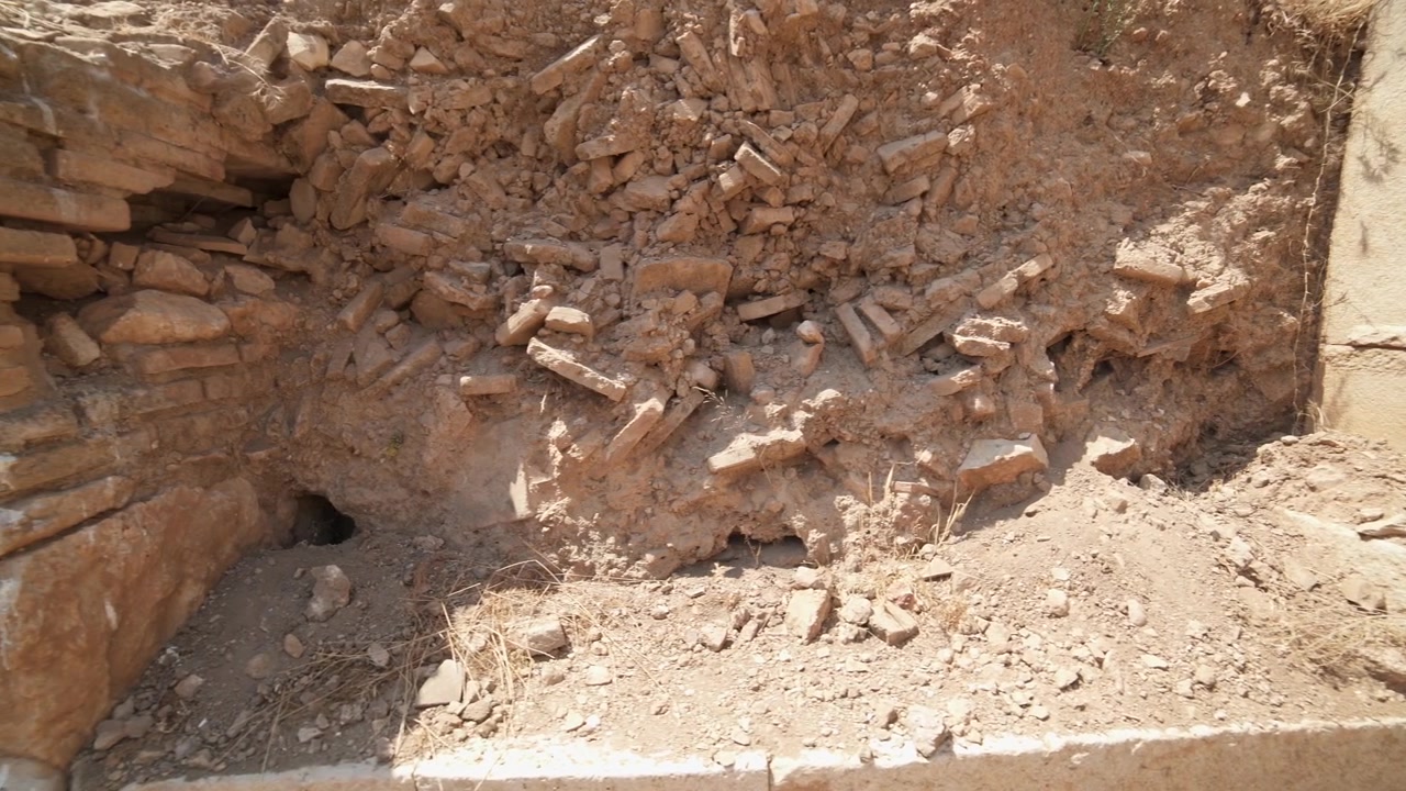 Gamle stenruiner og murstensvæg på arkæologisk udgravningssted
