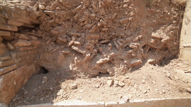 Gamle stenruiner og murstensvæg på arkæologisk udgravningssted