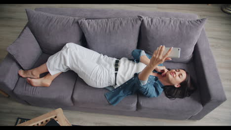 woman taking selfie on couch