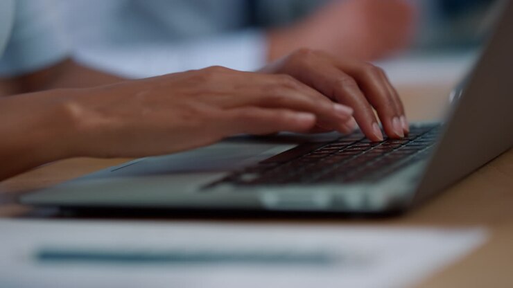 Unkenntliche Geschäftsfrau arbeitet am Laptop am Arbeitsplatz
