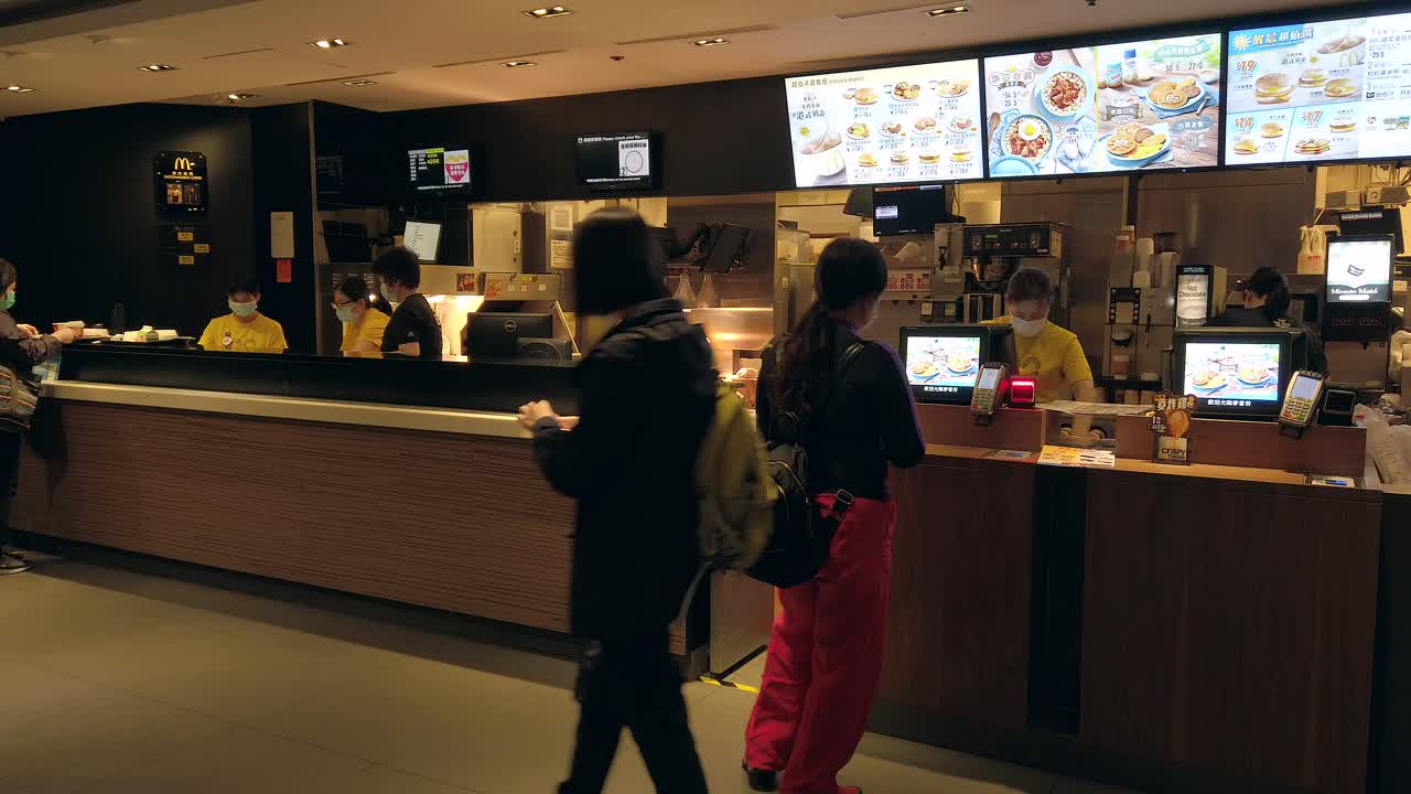 Corona Virus Pandemic, Mcdonalds front counter workers wearing protective face masks in downtown Hong Kong.