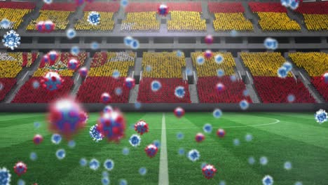 Animation-of-covid-19-cells-over-spanish-flag-in-empty-sports-stadium