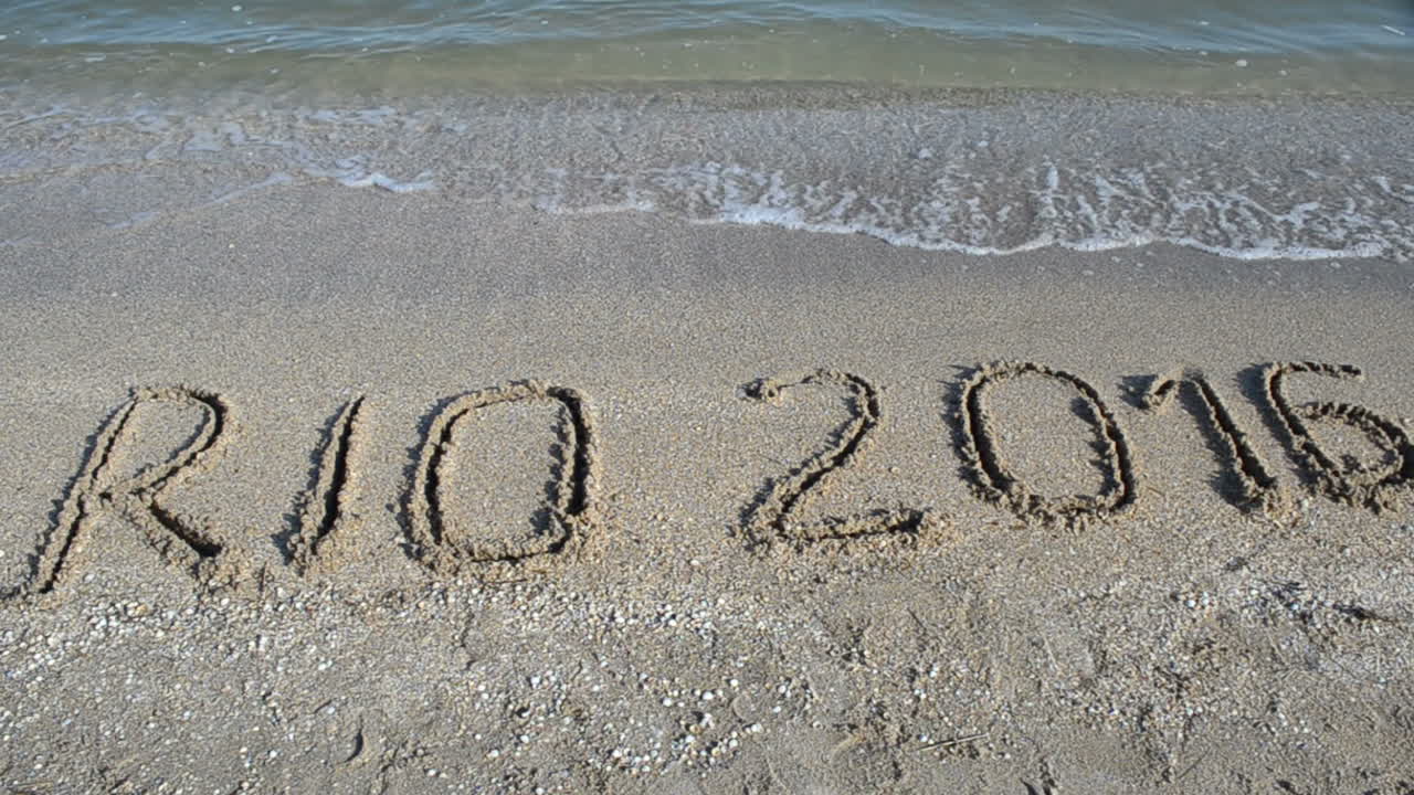 Rio 2016, en inskription i sandet på stranden. Symbol for olympiske lege i sandet på stranden.