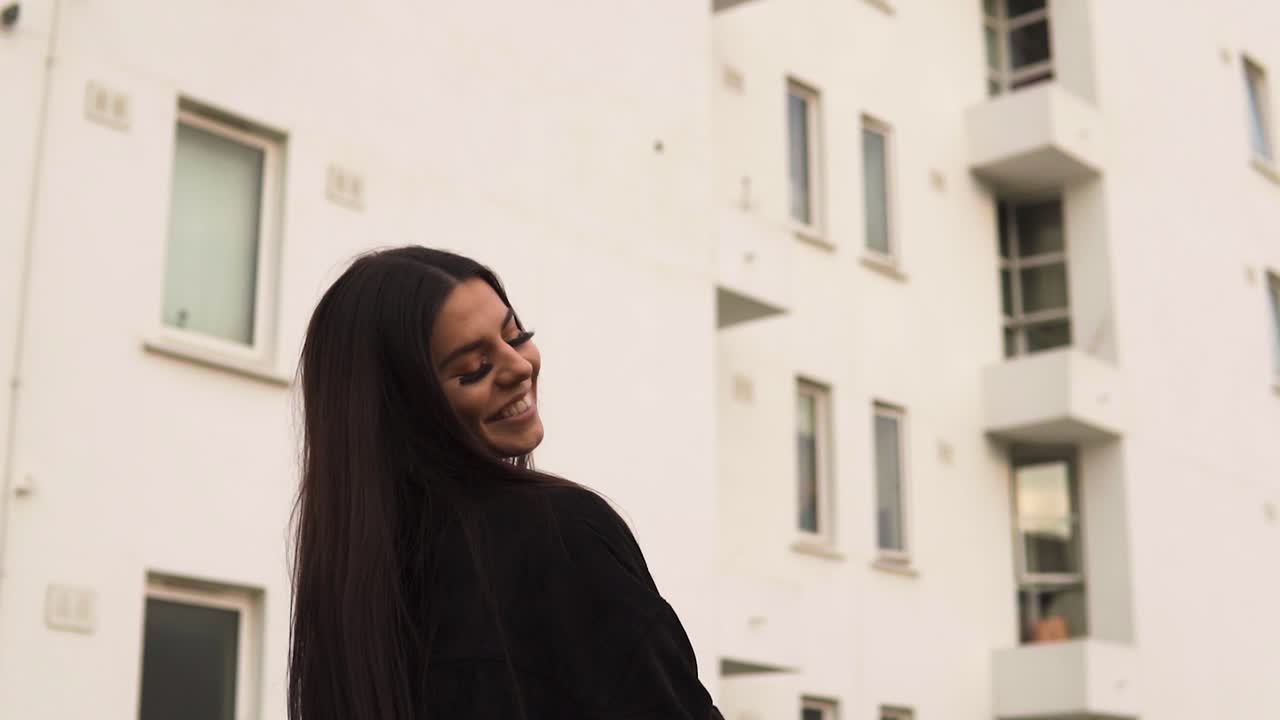 una joven modelo loca y espontánea que disfruta de su vida caminando por un lugar de verano con palmeras sonriendo sacando la lengua siendo descarada y provocativa hace que te enamores de su puesta de sol