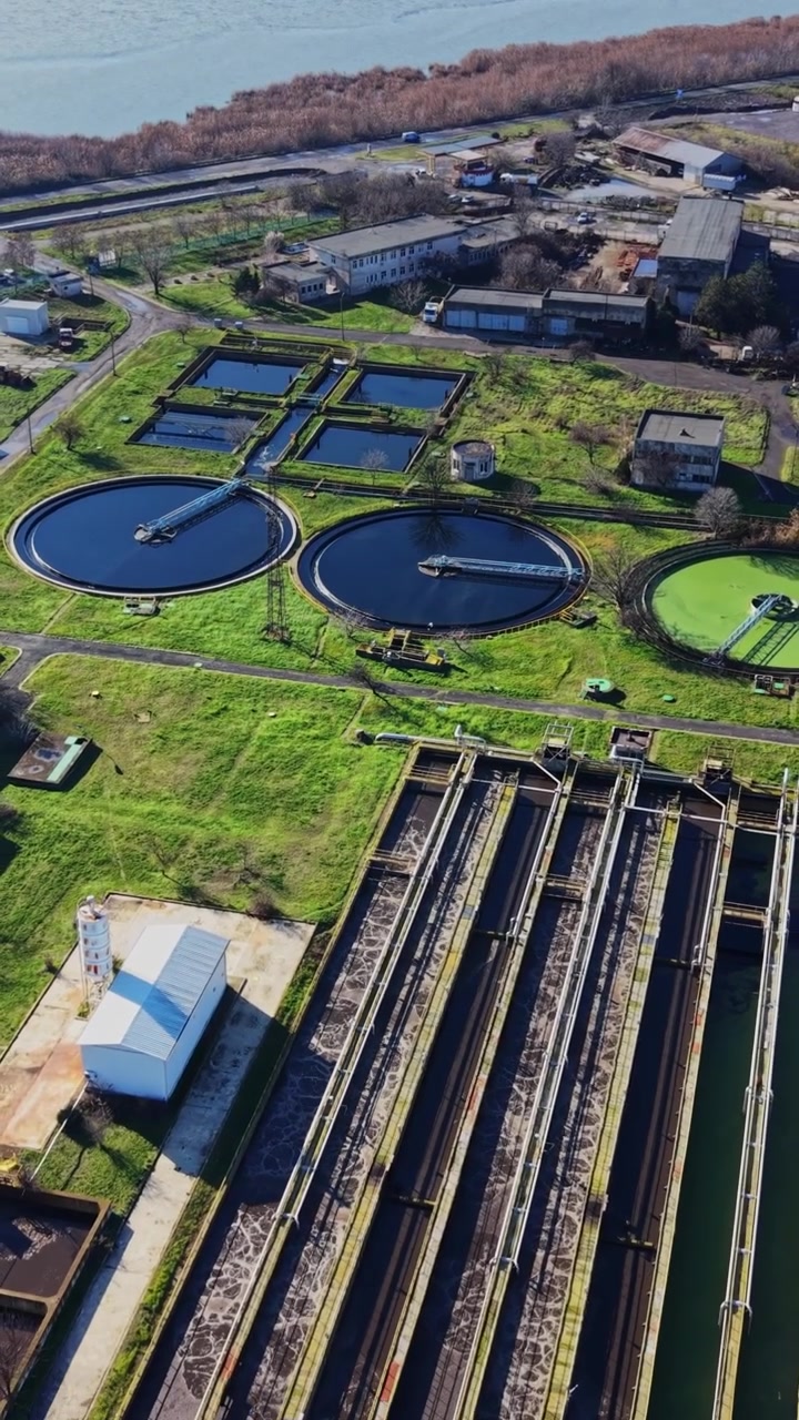 Water treatment facility with circular tanks and green fields in view