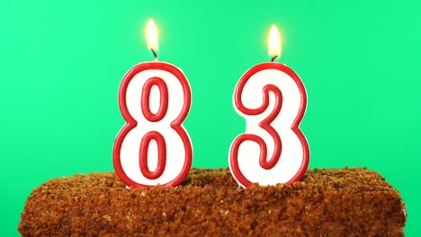 cake with the number 83 lighted candle. chroma key. green screen. isolated