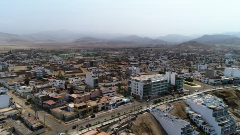 Aerial-view-of-a-people-riding-waves-on-a-coast-of-San-Bartolo,-in-sunny-Peru