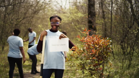 Portrait-of-african-american-activist-holding-poster-with-save-our-planet-message