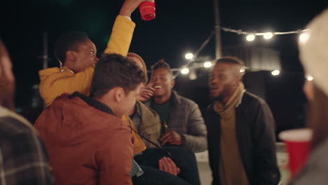 young-group-of-multiracial-friends-having-fun-dancing-playfully-together-enjoying-rooftop-party-at-night-laughing-celebrating-friendship