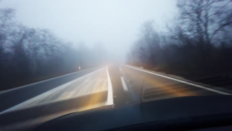 driving on a foggy road in winter season misty road and bad weather and visibility condition for driver, pov