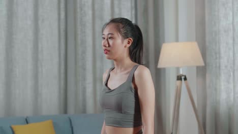 young asian trainer female in sports clothes speaking and doing yoga in high lunge pose while teaching exercise at home
