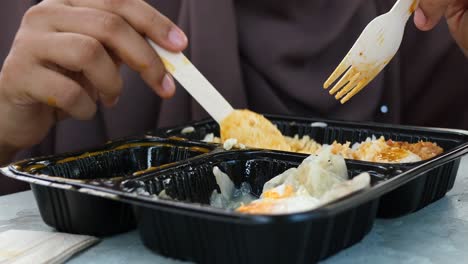 Curry-chicken-and-rice-in-a-take-away-plastic-packet-on-table