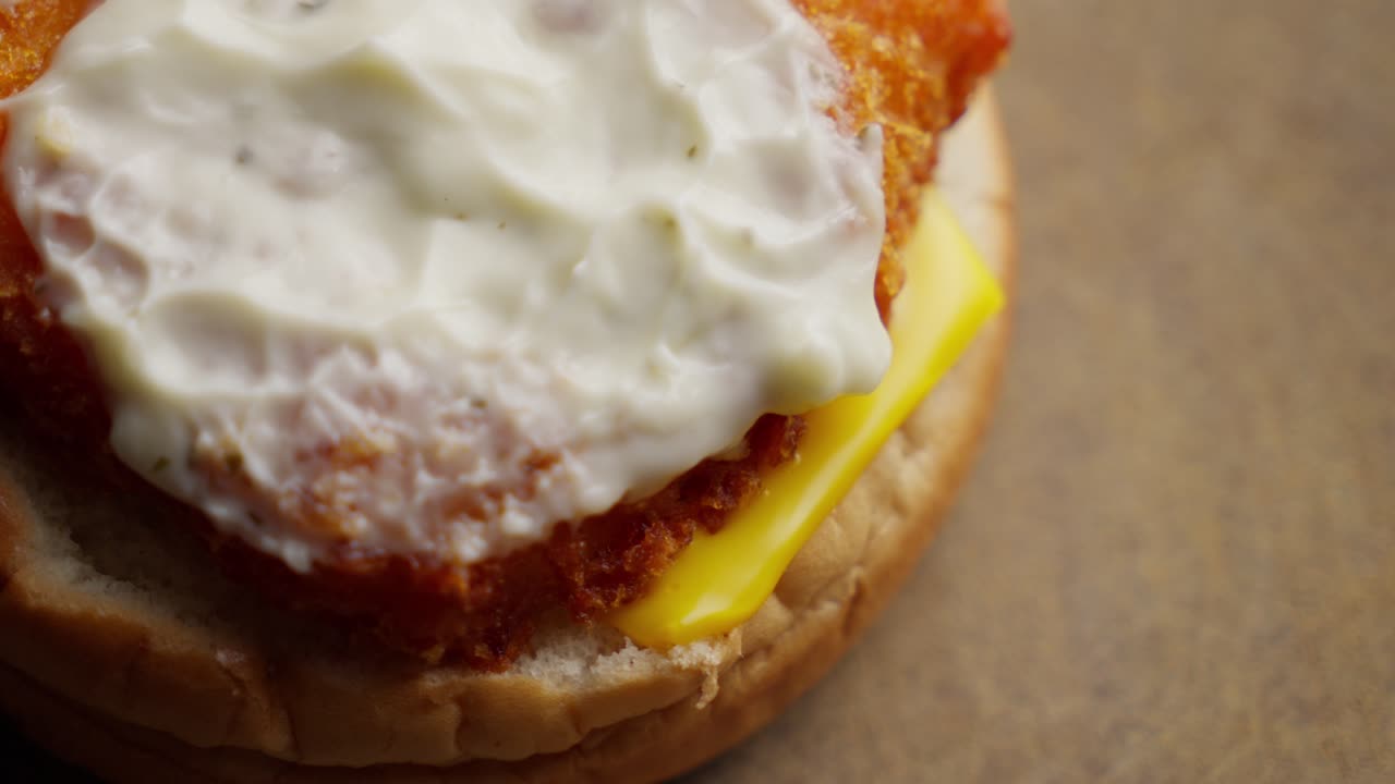 Panino aperto che rivela maionese, fish burger, formaggio, cibo spazzatura, malsano.