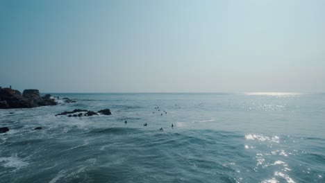 Static-shot-of-a-group-of-surfers-waiting-for-the-perfect-wave-to-roll-through