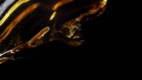 extreme closeup of liquid and ripples on surface, blowing air, abstract shot