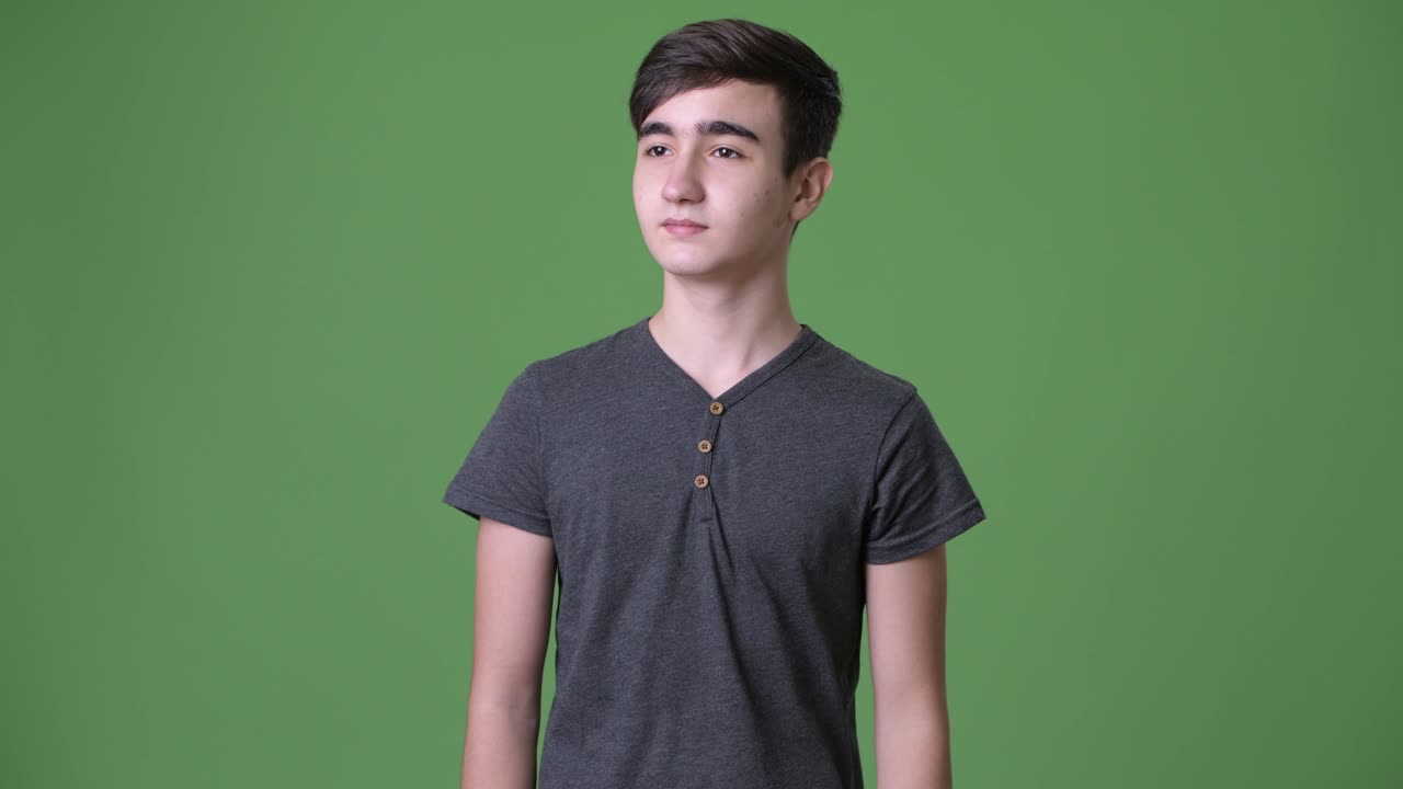 초록색 배경에 젊은 잘생긴 이란 십대 소년