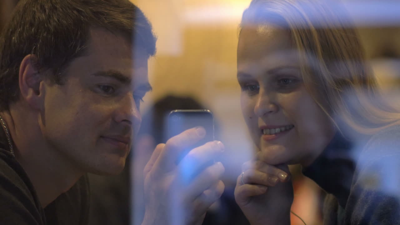 Young people looking through the photos on cell phone