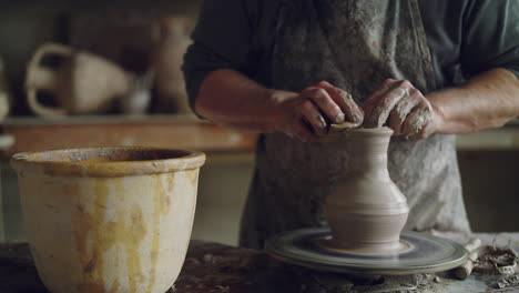 A Potter Shaping Clay on a Wheel