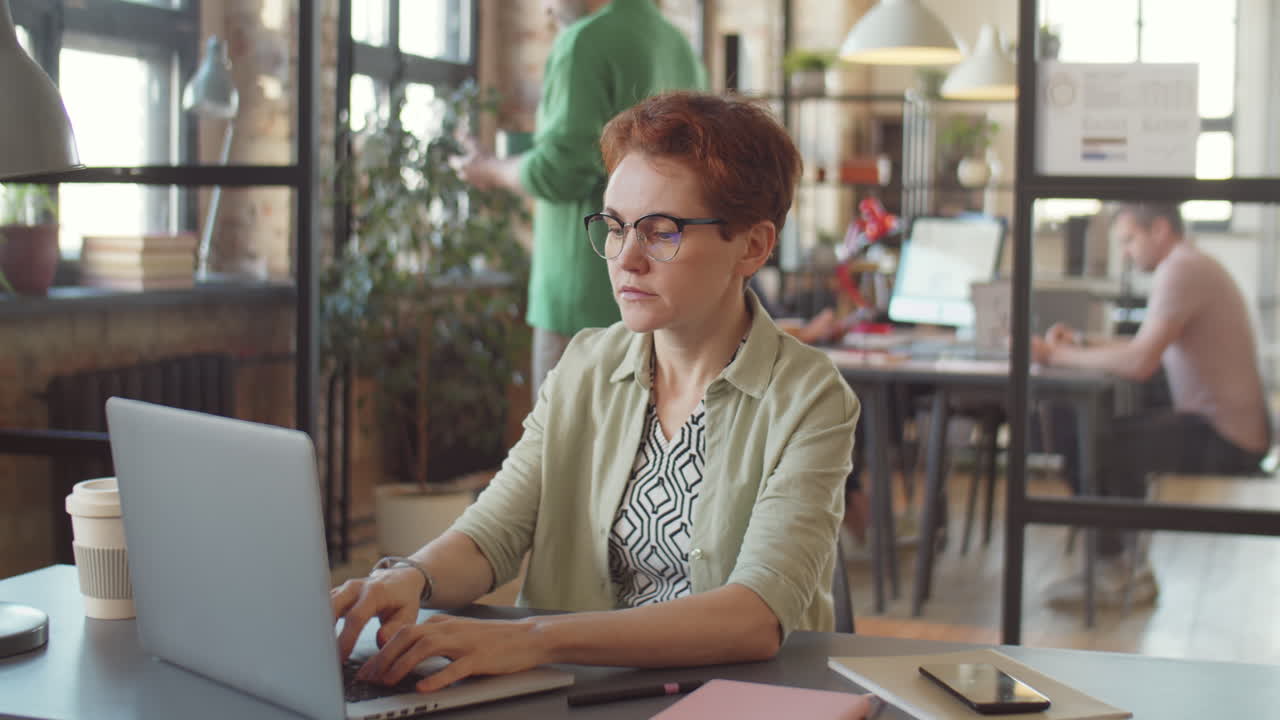 Woman Working on Laptop in Open Office