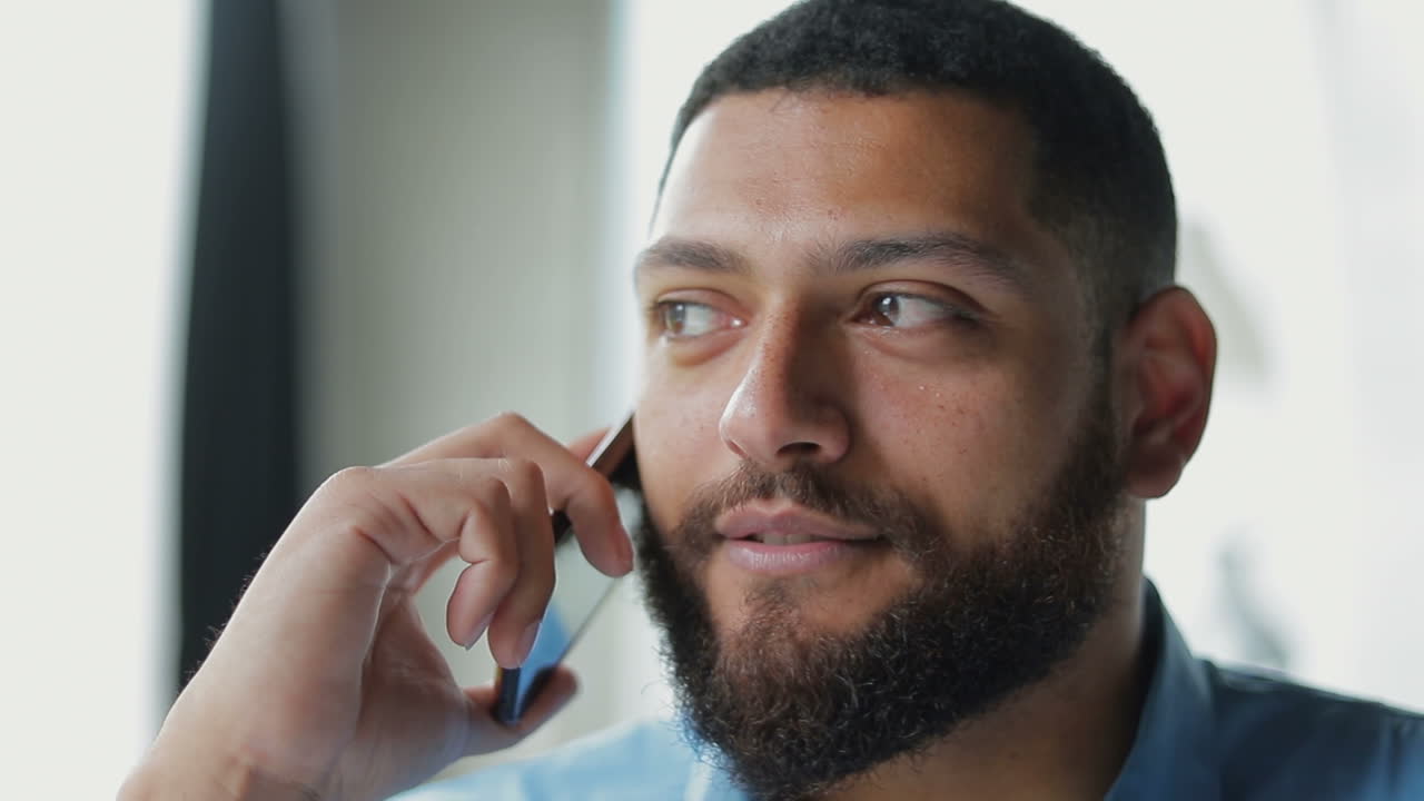 Jovem sorridente falando no smartphone e olhando para o lado