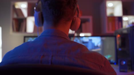 young handsome professional player playing in online sports game at home.