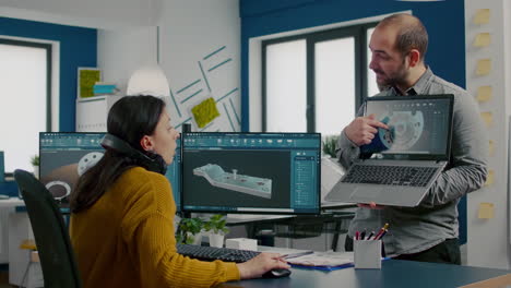 engineer holding laptop and pointing on display