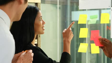 executives discussing over sticky note on glass wall 4k