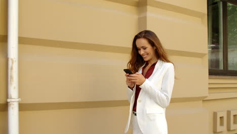 happy business woman texting mobile phone outdoors. smiling businesswoman