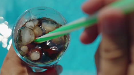 person drinking soda by the pool