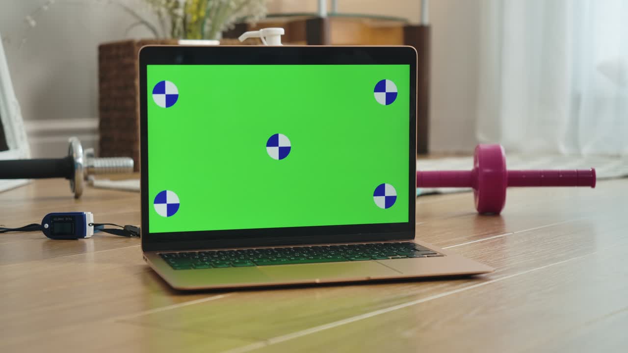 primer plano de la pantalla del portátil chromakey con la mano femenina tomando bandas de resistencia tendidas en el suelo. mujer deportiva caucásica irreconocible usando página web con lección de entrenamiento. cine 4k prores hq.