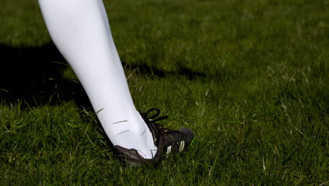 football player kicking the ball on grass