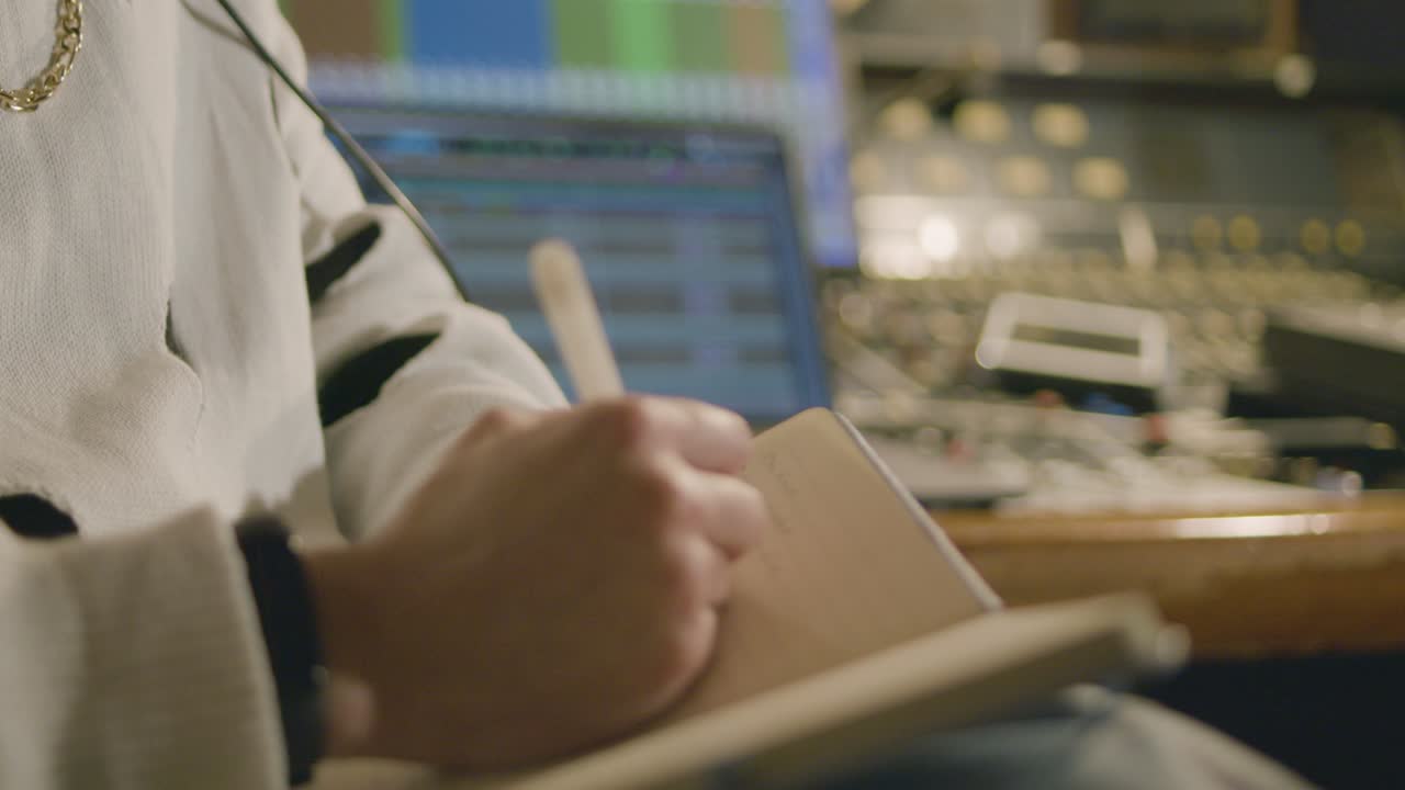 hombre trabajando en un estudio de grabación de música, tomando notas