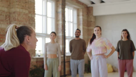 entrenadora que muestra danza a estudiantes multiétnicos