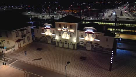 Aerial-drone-shot-over-empty-entrance-of-railway-station-in-Aveiro,-Portugal-at-night-time