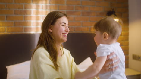 woman playing with her baby in the bedroom at home