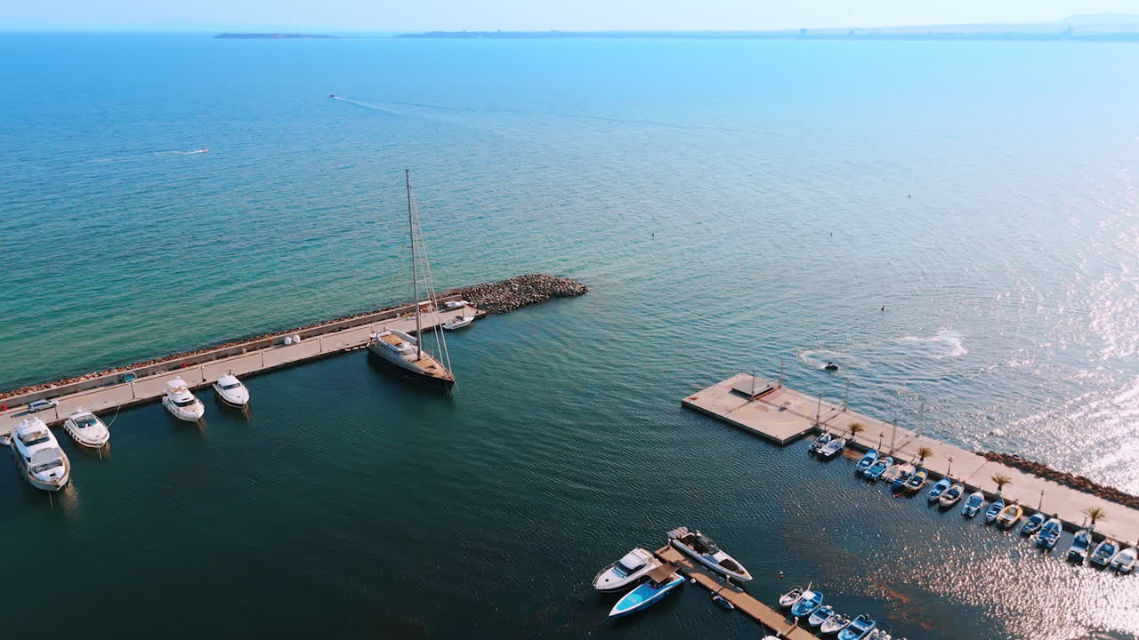 Diverse water vehicles standing at the berths. Yachts, boats, jet ski scooters near the piers. Aerial view