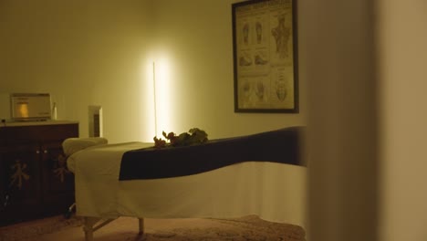 clip showcasing a massage bed and artwork depicting the human muscular system displayed on the wall