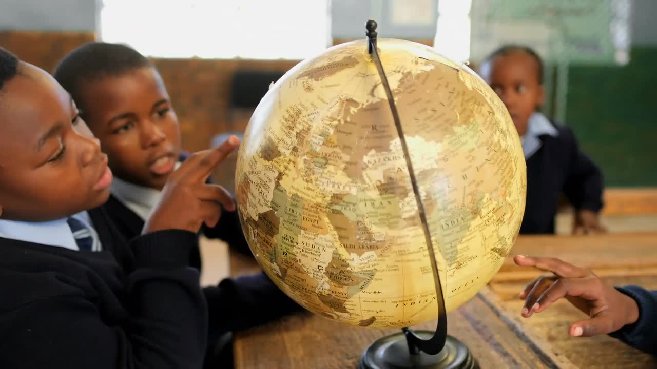 Schoolkids using globe in classroom at school 4k