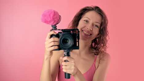 woman vlogger recording video with pink camera
