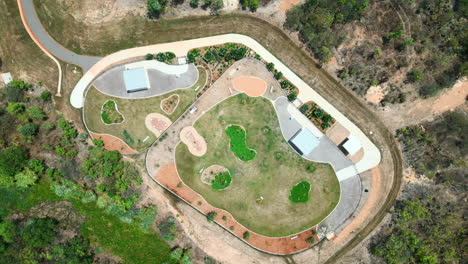 parque para perros moderno, con césped exuberante vibrante, camas de jardín de grava cuidadosamente dispuestas, pasarelas de hormigón y áreas de asientos sombreadas