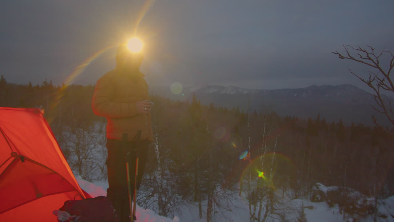 Man Standing by Tent at Campsite on Mountain Top