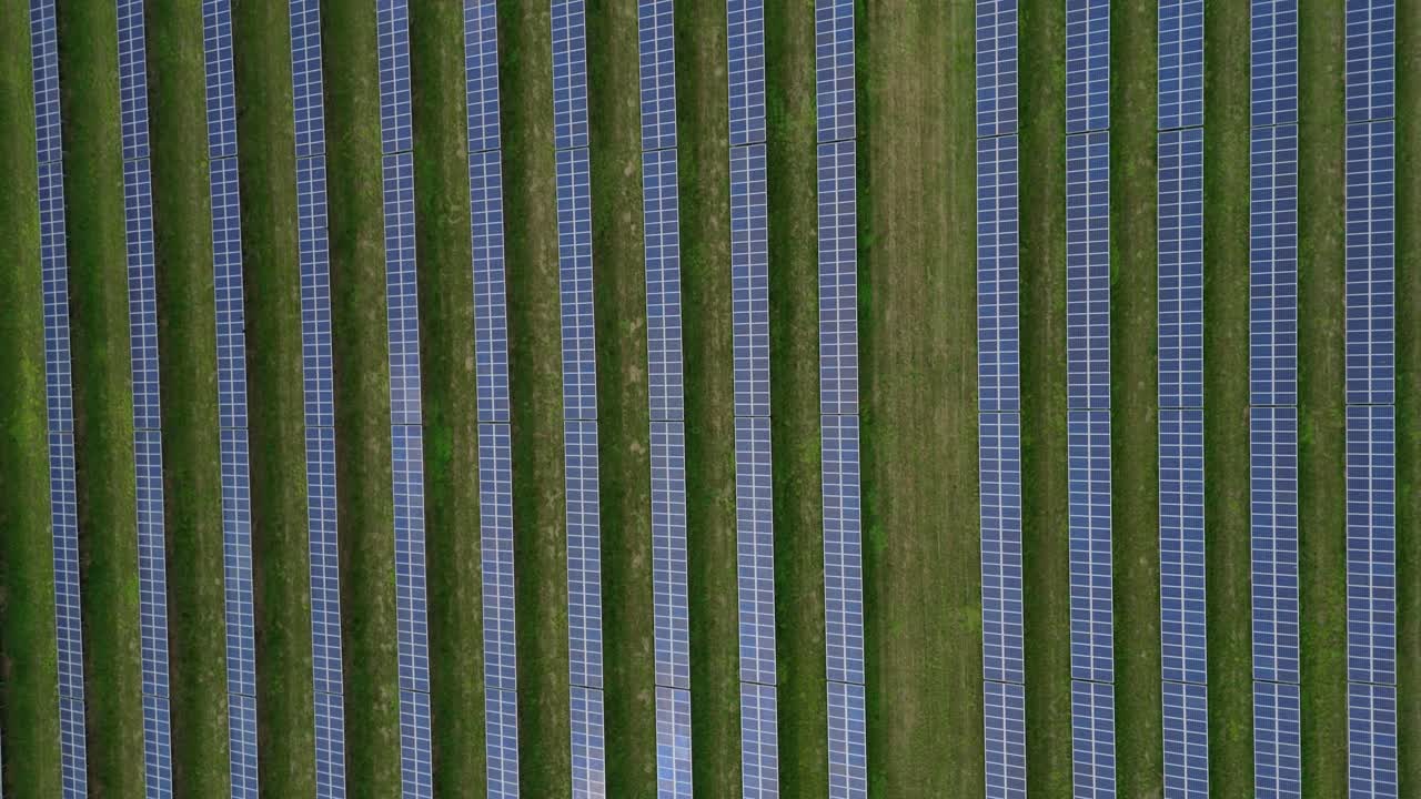 Aerial cinematic panorama of solar panel arrays in Yorkshire UK fields producing renewable electricity and showcasing sustainable energy infrastructure in countryside