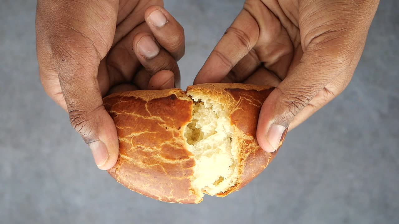 Hands holding a piece of bread