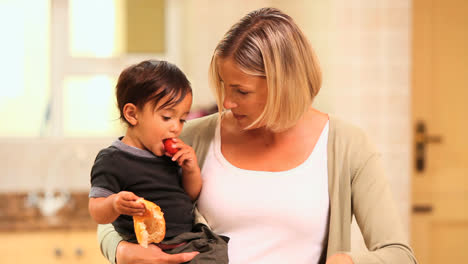 Mother-cooking-while-holding-baby-on-her-hip