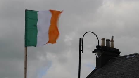 Rápido-Baile-De-La-Bandera-Irlandesa-En-Medio-Del-Cielo-Nublado-Y-La-Tradicional-Azotea