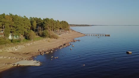 rocky beach shore with many boulders and blue sea nordic nature, naked trees